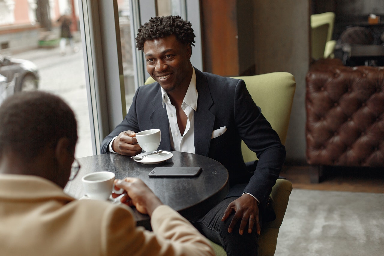 Two men in a tea shop engaged in a discussion